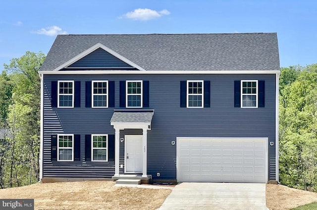 view of front of house with a garage, concrete driveway, and roof with shingles