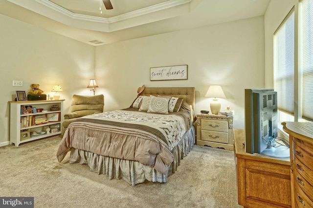 carpeted bedroom with ornamental molding, ceiling fan, and a tray ceiling