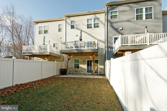 back of house with cooling unit, a patio, and a lawn