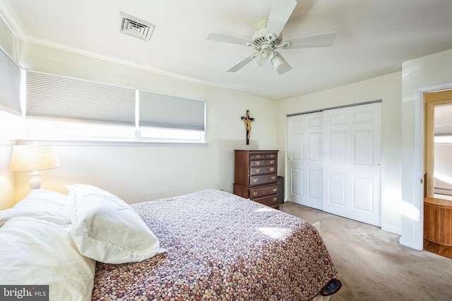 carpeted bedroom featuring ceiling fan and a closet