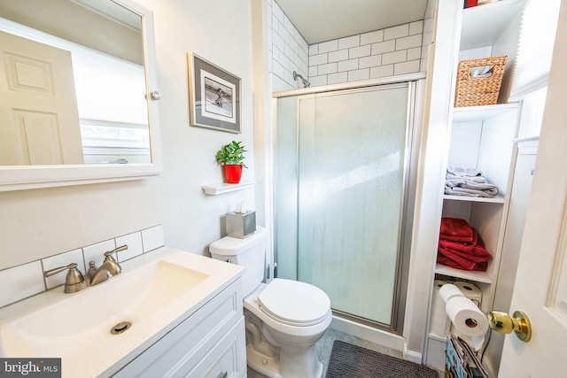 bathroom featuring vanity, a shower with shower door, and toilet