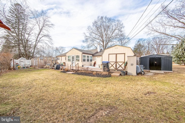 rear view of house featuring a yard, a deck, and a storage shed