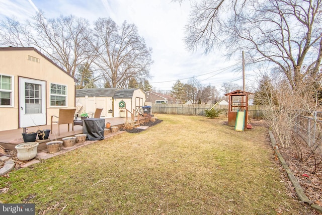 view of yard with a storage shed and a playground