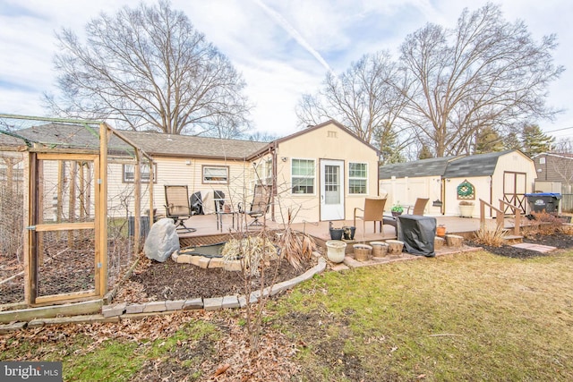 rear view of property with a wooden deck, a storage shed, and a lawn