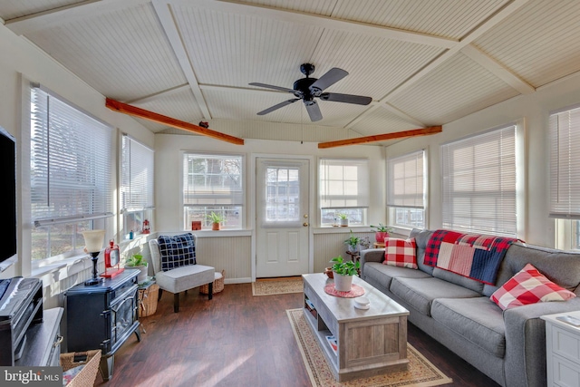 sunroom / solarium with lofted ceiling, a wood stove, a wealth of natural light, and ceiling fan