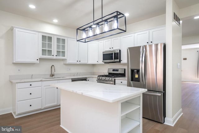 kitchen featuring stainless steel appliances, sink, a kitchen island, and white cabinets