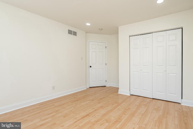 unfurnished bedroom with light hardwood / wood-style floors and a closet