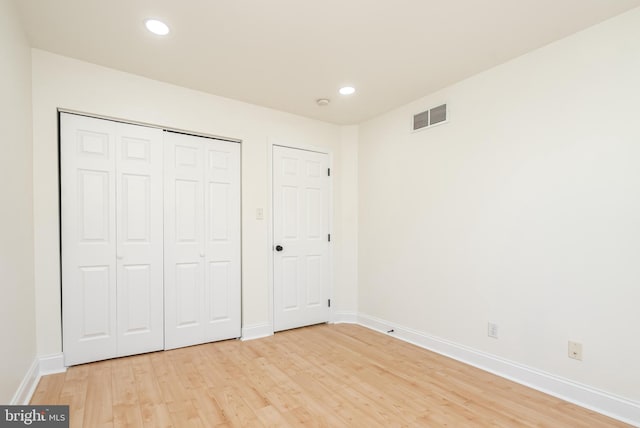 unfurnished bedroom with a closet and light hardwood / wood-style flooring