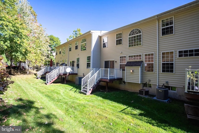 rear view of house featuring a yard and central AC unit