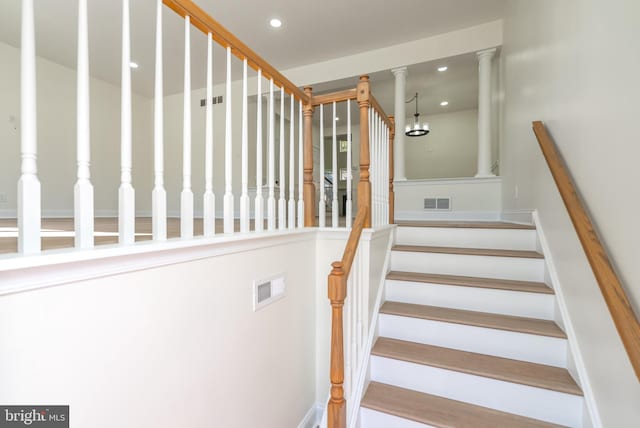 staircase featuring decorative columns