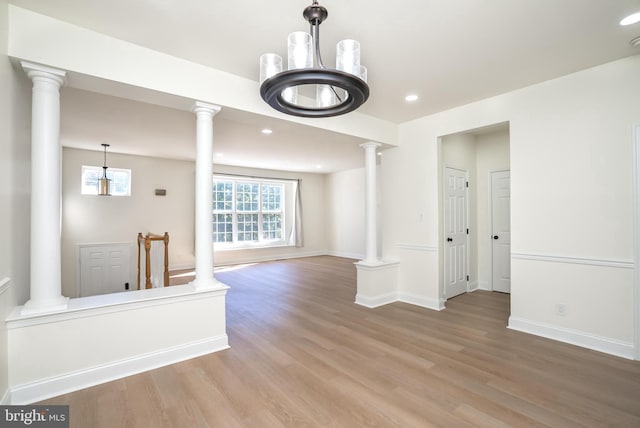 unfurnished living room with hardwood / wood-style flooring and decorative columns