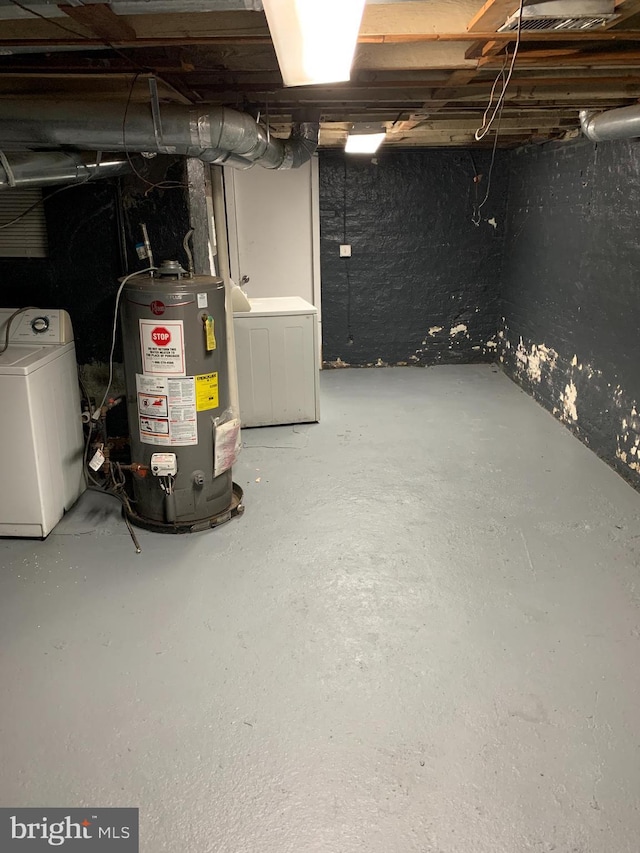 basement featuring gas water heater and washer / dryer