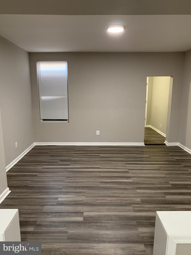 spare room with dark wood-type flooring