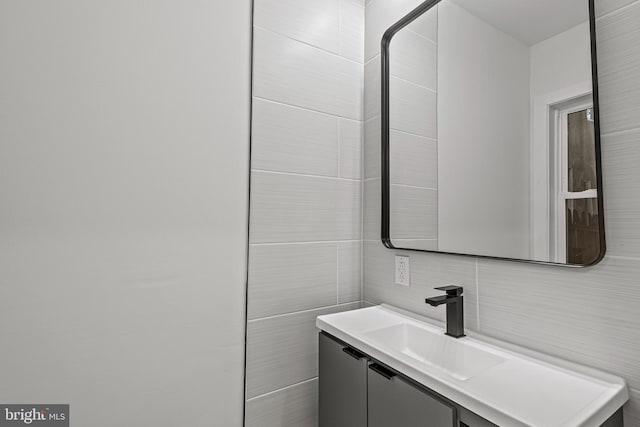 bathroom featuring vanity, tile walls, and backsplash