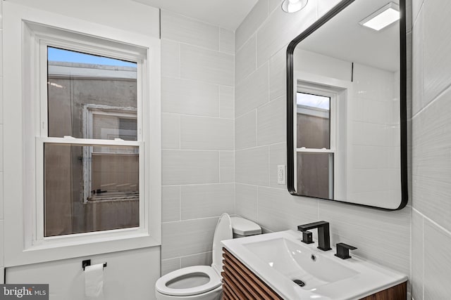 bathroom featuring tile walls, vanity, and toilet