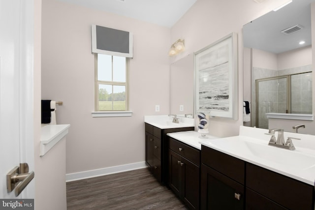 bathroom featuring visible vents, a shower stall, baseboards, and a sink