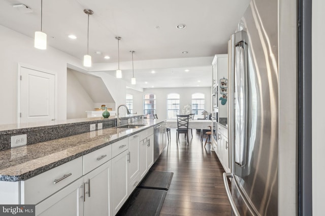 kitchen featuring dark wood-style floors, white cabinets, stainless steel appliances, and a sink