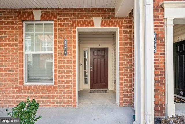 entrance to property featuring brick siding