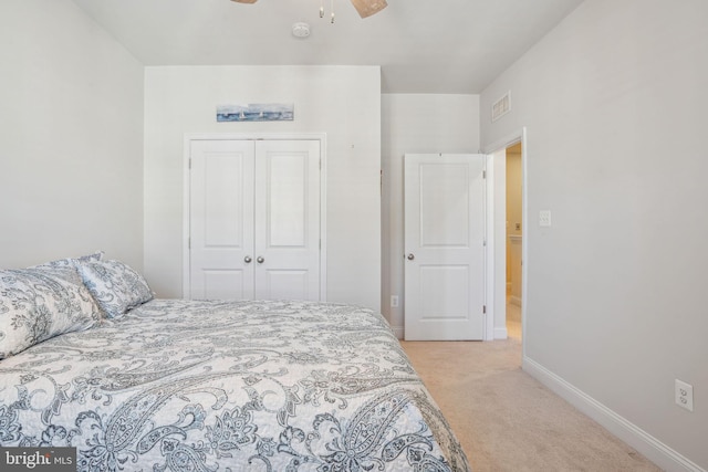 bedroom with a ceiling fan, baseboards, visible vents, a closet, and light carpet