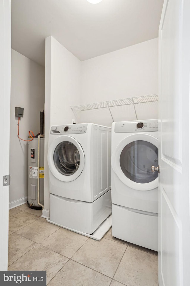 laundry room with washer and clothes dryer, light tile patterned flooring, laundry area, and water heater