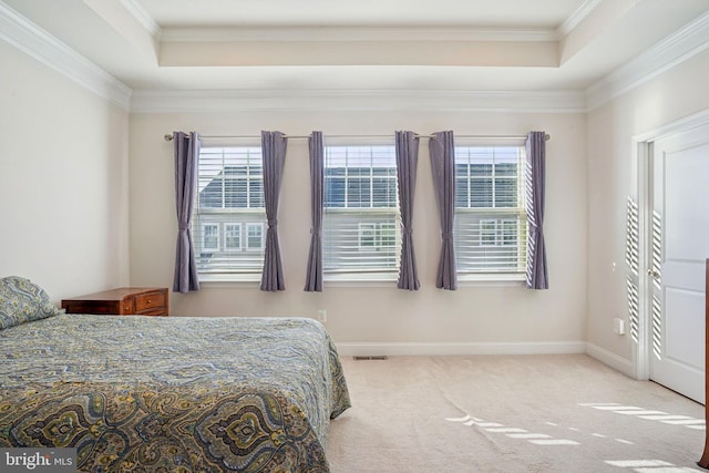 bedroom with baseboards, carpet, a tray ceiling, and ornamental molding