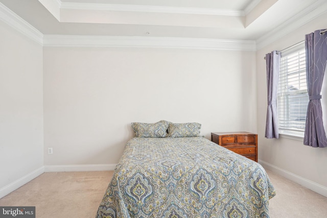 carpeted bedroom with baseboards, a raised ceiling, and crown molding