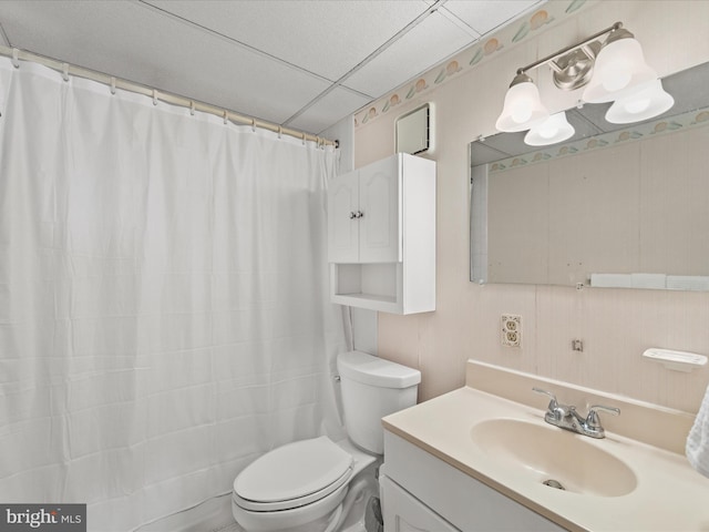 bathroom featuring vanity, toilet, curtained shower, and a drop ceiling