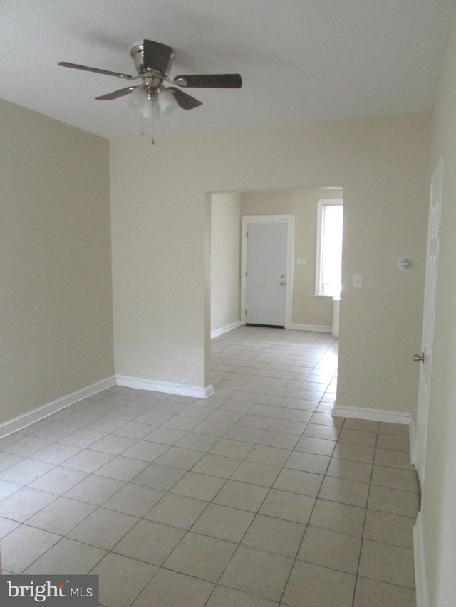 tiled empty room featuring ceiling fan