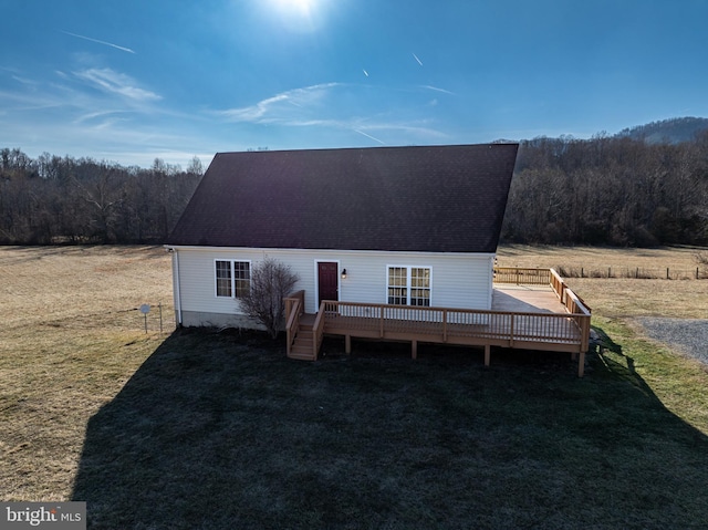 view of front of house with a wooden deck and a front lawn