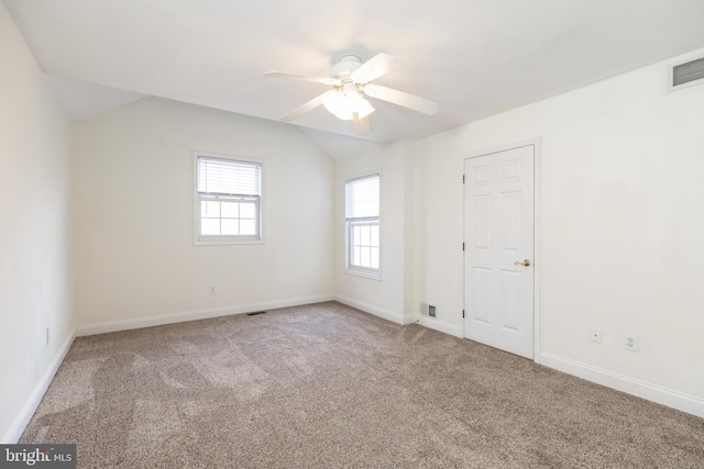 empty room with lofted ceiling, carpet flooring, and ceiling fan