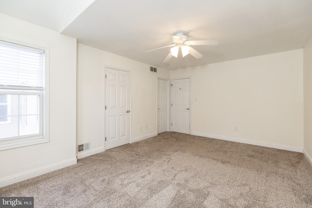 empty room with ceiling fan and carpet flooring