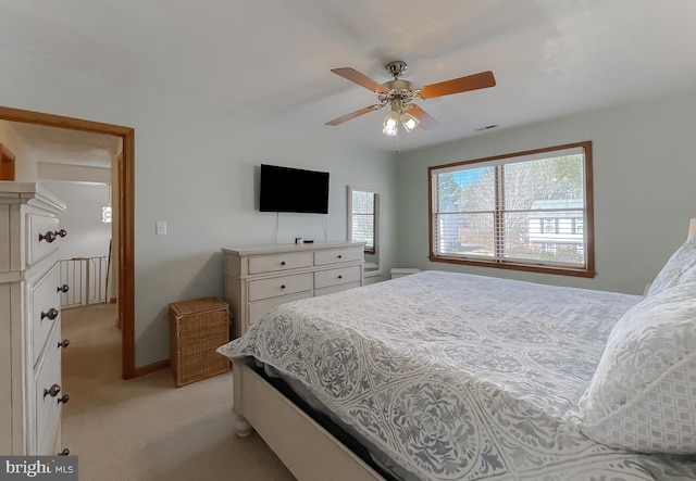 bedroom with light carpet, visible vents, and a ceiling fan