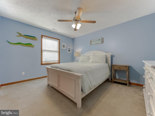 bedroom featuring a textured ceiling, baseboards, visible vents, and light colored carpet