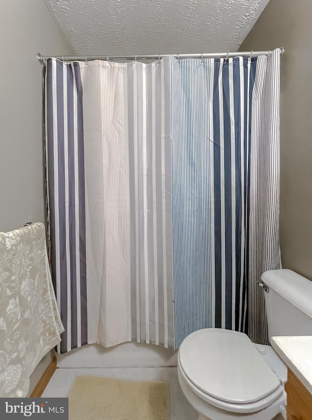 full bath featuring shower / bathtub combination with curtain, toilet, vanity, and a textured ceiling