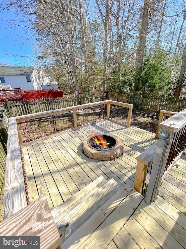 wooden terrace with an outdoor fire pit and fence