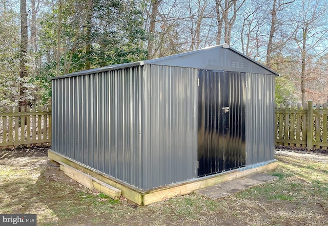 view of outdoor structure featuring an outbuilding and fence