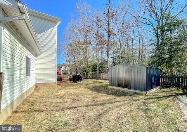 view of yard featuring a storage shed, a fenced backyard, and an outdoor structure