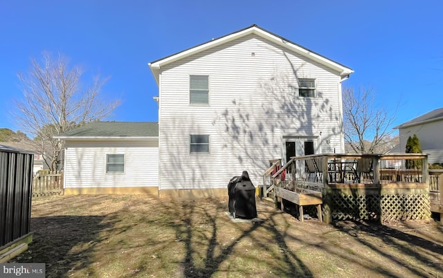 back of house featuring fence, a deck, and french doors