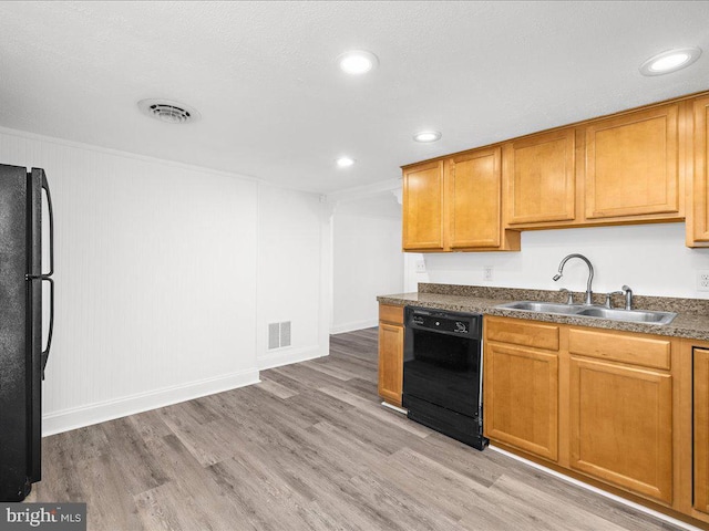 kitchen featuring sink, light hardwood / wood-style floors, and black appliances