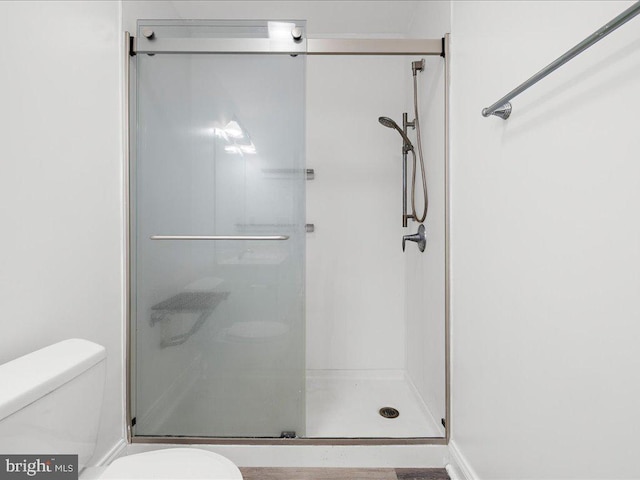 bathroom with an enclosed shower and toilet