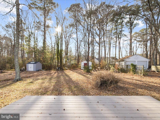 view of yard featuring a wooden deck and a storage unit