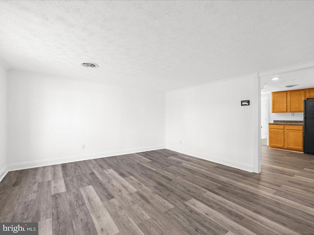 unfurnished living room with hardwood / wood-style floors and a textured ceiling