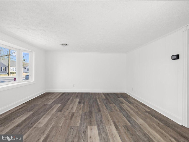 empty room featuring dark hardwood / wood-style floors and a textured ceiling