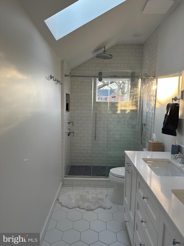 bathroom with vanity, lofted ceiling with skylight, toilet, and walk in shower