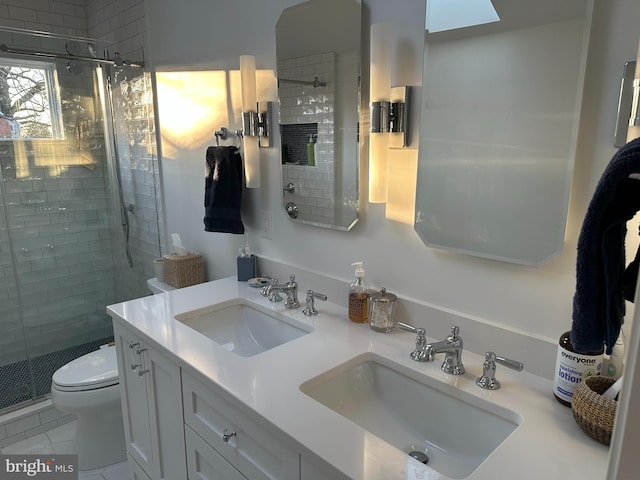 bathroom with vanity, toilet, and a shower with door