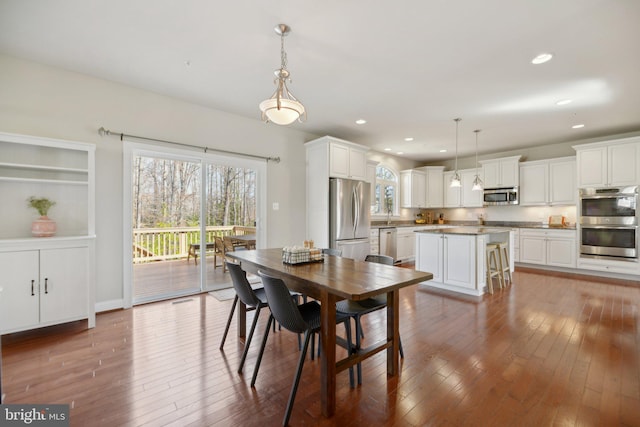 dining space with hardwood / wood-style floors and recessed lighting