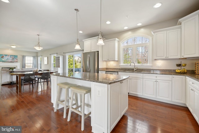 kitchen featuring a sink, dark wood-style floors, white cabinets, and freestanding refrigerator