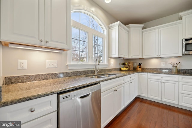 kitchen featuring dark wood finished floors, white cabinetry, stainless steel appliances, and a sink