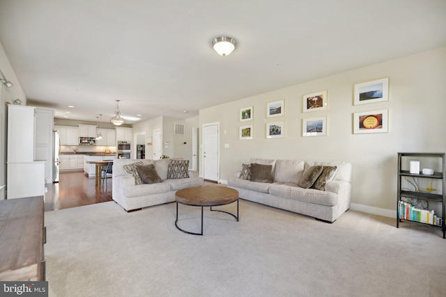 carpeted living room featuring visible vents and baseboards