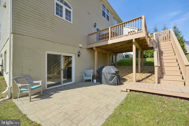 view of patio / terrace with a grill, a wooden deck, and stairs